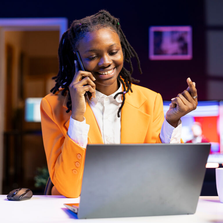 Happy woman receiving pleasing phone call from friend while working from home